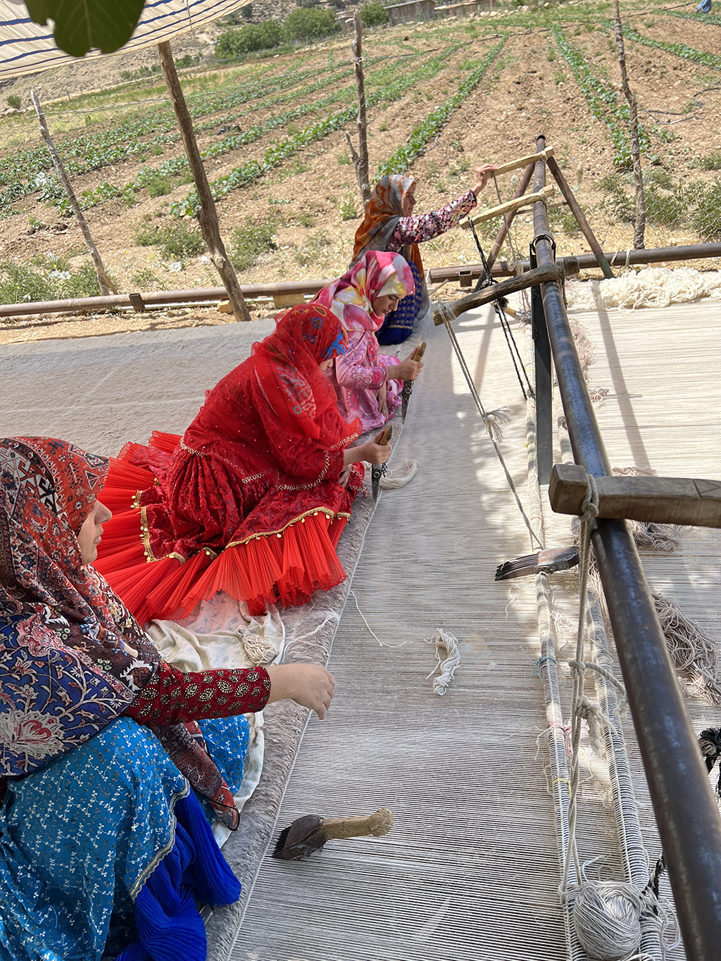 Master artisan hand-knotting a luxury custom rug on a traditional loom